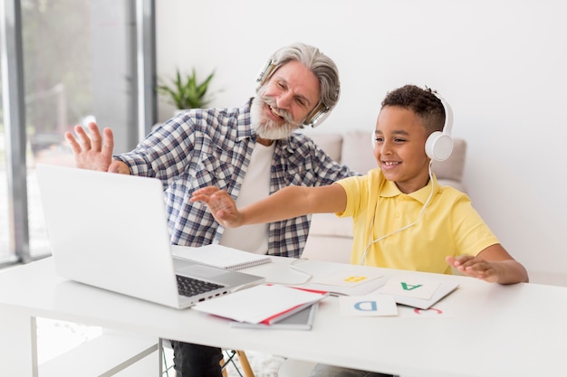 Teacher and student waving at laptop