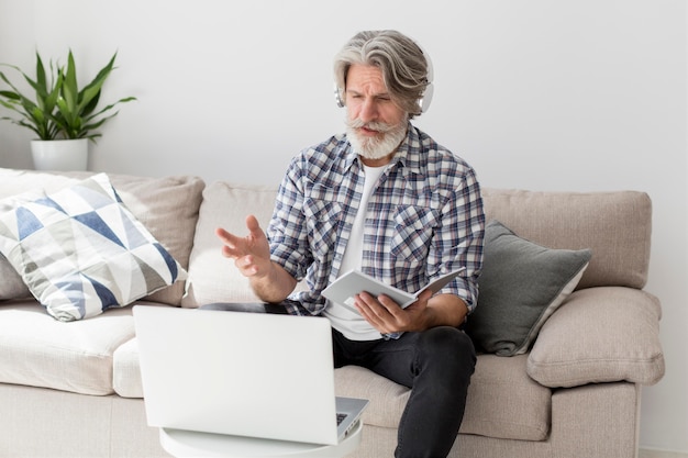 Teacher talking at laptop holding notebook