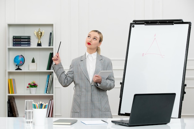 Teacher young cute instructor in suit in classrom with laptop and whiteboard looking up