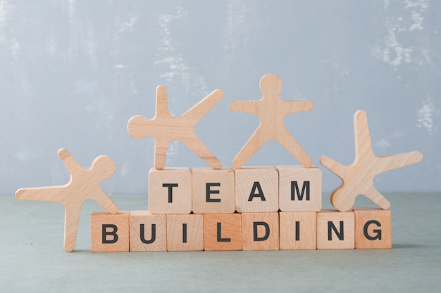 Free Photo team building concept with wooden blocks, wooden human figures on it side view.