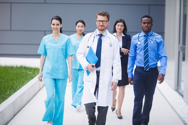 Team of doctors walking in a row