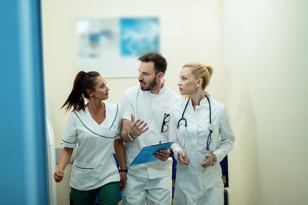 Free photo team of healthcare workers talking about medical reports while rushing through the lobby in the hospital