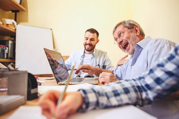 Free Photo team job. old and young men working with new project in office