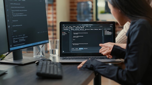 Free Photo team of programmers talking about algorithm running on laptop screen pointing at source code while sitting at desk. software developers collaborating on data coding group project.