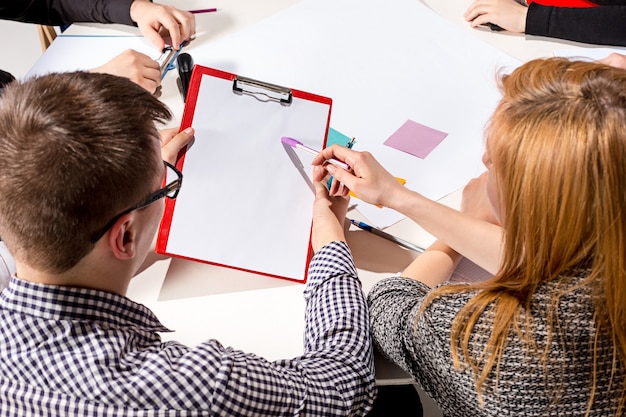 Free photo team sitting behind desk, checking reports, talking. business concept of collaboration, team work, meeting