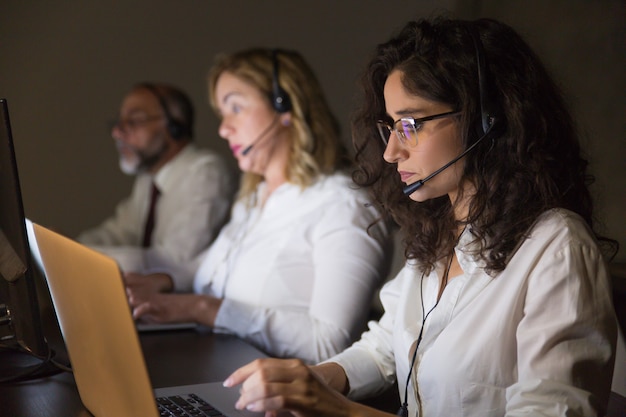 Team of teleworkers working in dark office