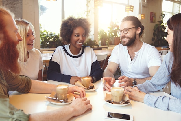 Team of young colleagues having meeting at cafe