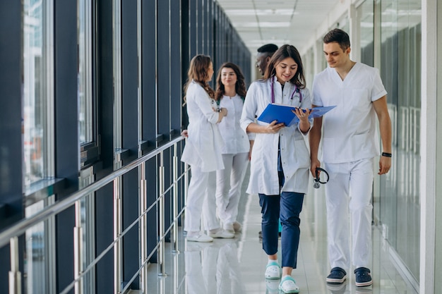 Free photo team of young specialist doctors standing in the corridor of the hospital