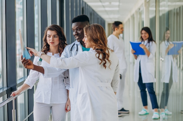 Free photo team of young specialist doctors standing in the corridor of the hospital