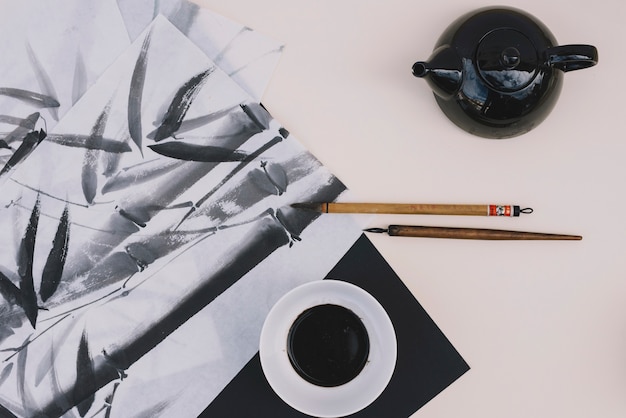 Teapot and ink near bamboo drawing