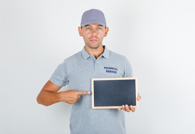 Free Photo technical service man in grey t-shirt with cap holding blackboard