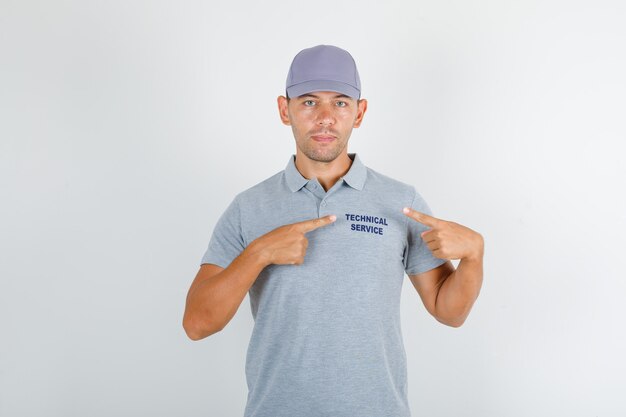 Technical service man showing text on uniform in grey t-shirt with cap