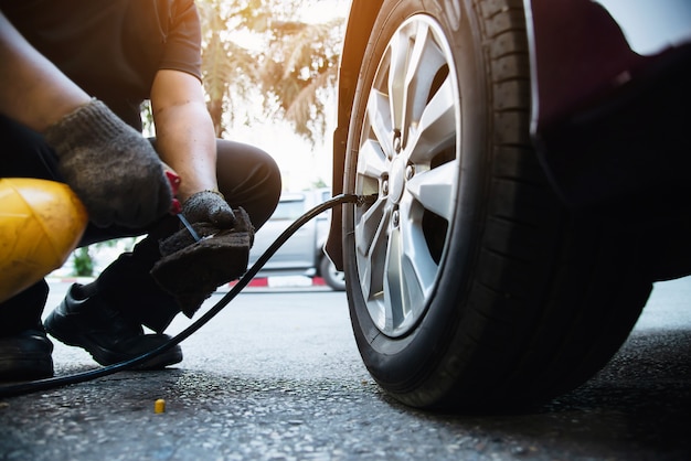 Technician is inflate car tire - car maintenance service transportation safety concept