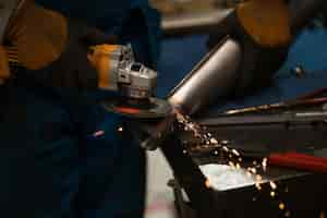 Free photo technician worker cutting metal with many sharp sparks using equipments to cat iron