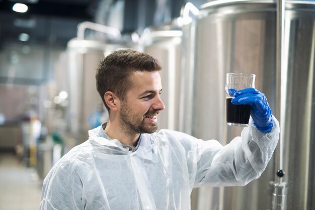 Technologist checking product quality in beverage alcohol production plant