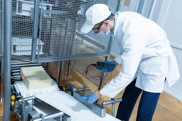 Free photo technologist make set up of the production line while standing near digital screen at the department of dairy factory