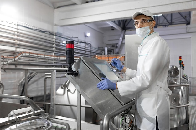 Free photo technologist make set up of the production line while standing near digital screen at the department of dairy factory