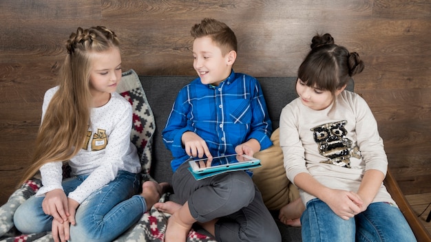 Free photo technology concept with three kids on couch