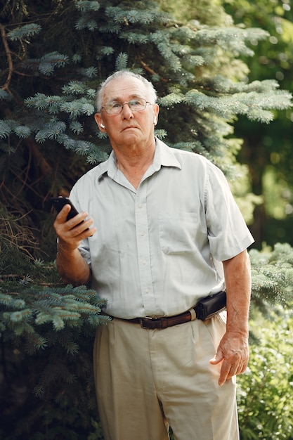 Free photo technology, people and communication concept. senior man at summer park. grangfather using a phone.