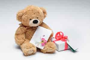 Free photo teddy bears couple with red heart and gift on white.