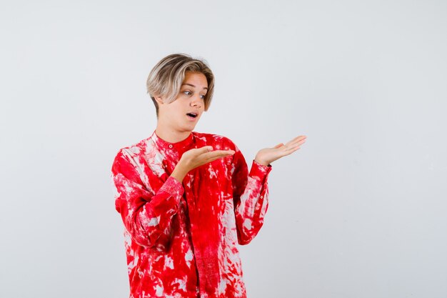 Teen blonde male in oversized shirt pretending to hold something