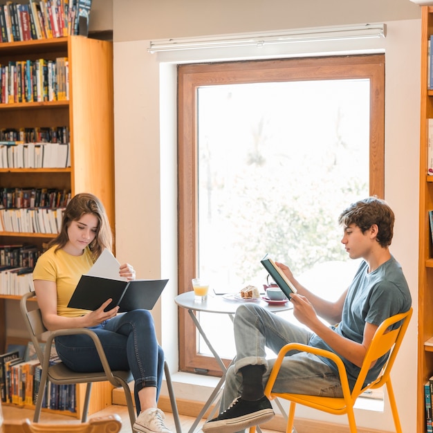 Free photo teen couple reading in library