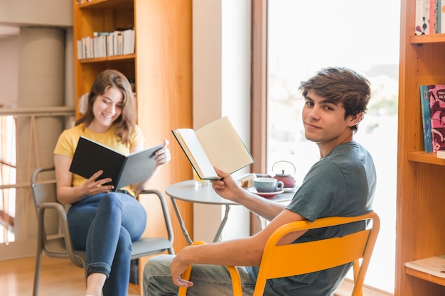 Teen couple reading in library