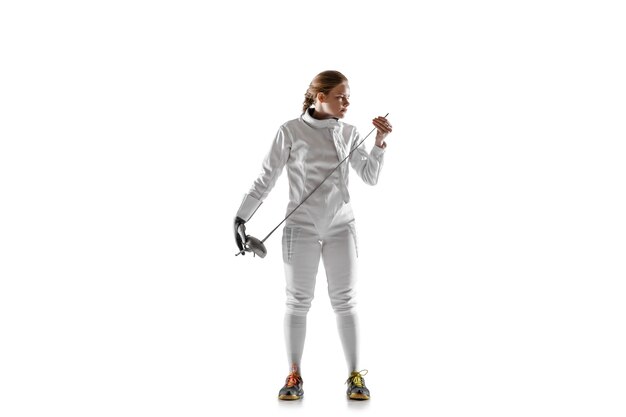 Teen girl in fencing costume with sword in hand isolated on white studio background.