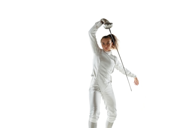 Teen girl in fencing costume with sword in hand isolated on white wall