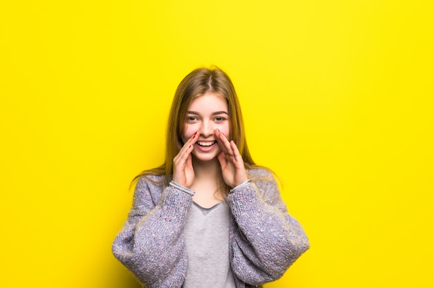 The teen girl shouts, having combined hands in a megaphone isolated