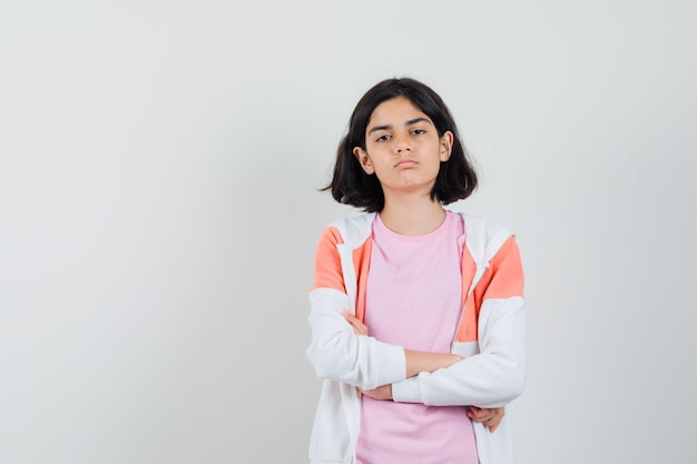 Free photo teen girl standing with crossed arms in jacket,pink shirt and looking serious.