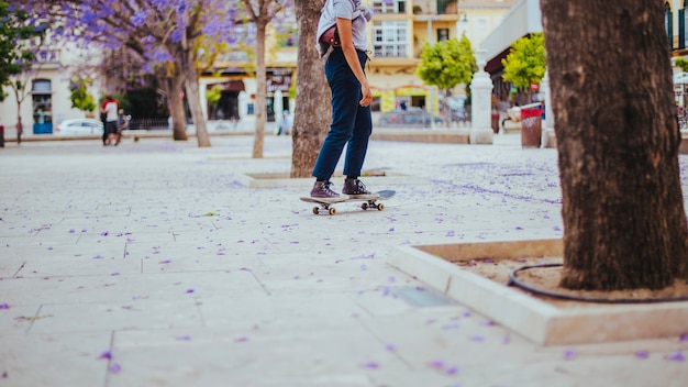 Teen riding skateboard on pavement