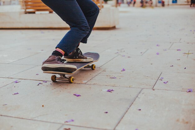 Teen riding skateboard on paving flag