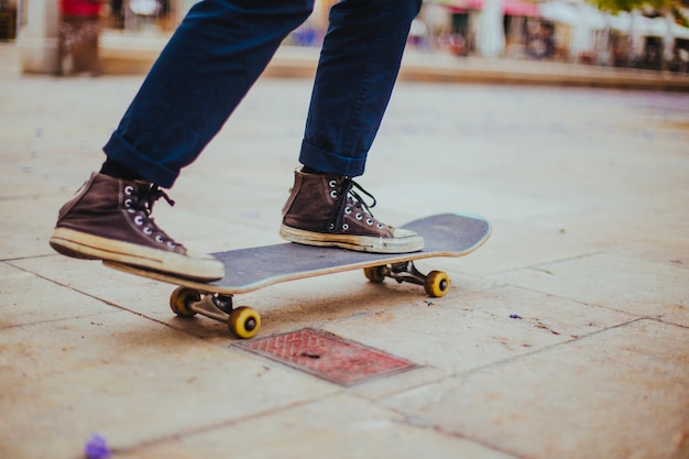 Teen riding skateboard on paving flag