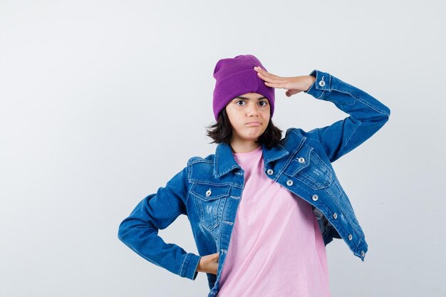 Teen woman in checkered shirt and beanie gesticulating isolated