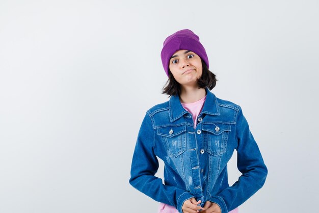 Teen woman in checkered shirt and beanie gesticulating isolated