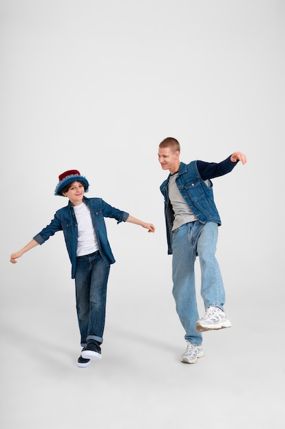 Free Photo teenage boy and his younger brother wearing denim outfits together