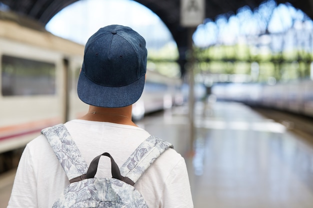 Free photo teenage boy with backpack and wearing capent