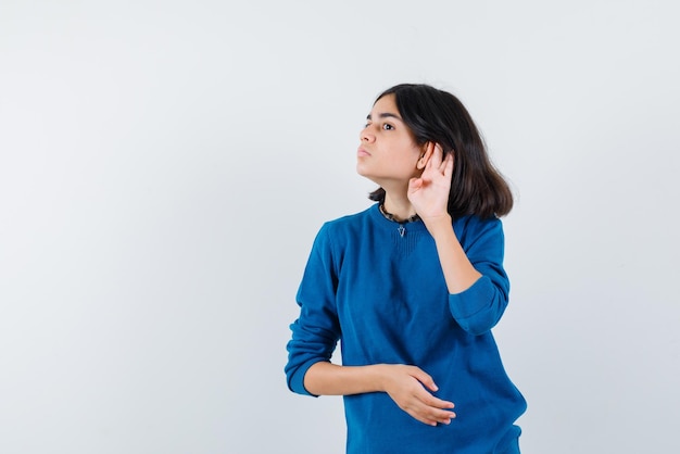 Teenage girl doing a hard of hearing hand gesture on white background