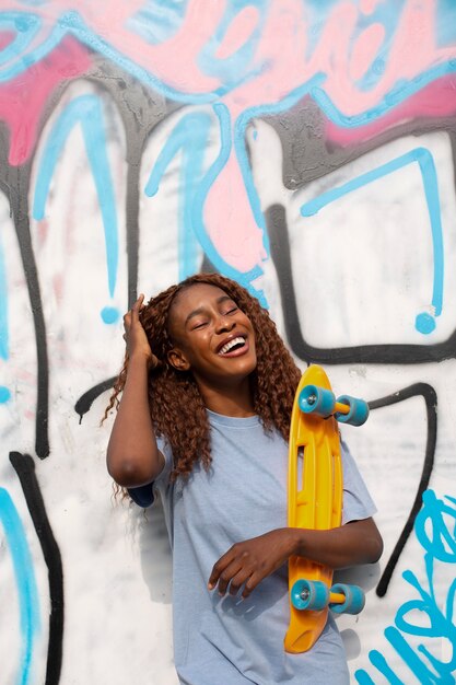 Teenage girl posing at park with skateboard