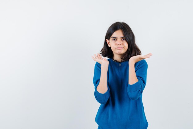 Teenage girl with puckering lips opening her hands widely on white background