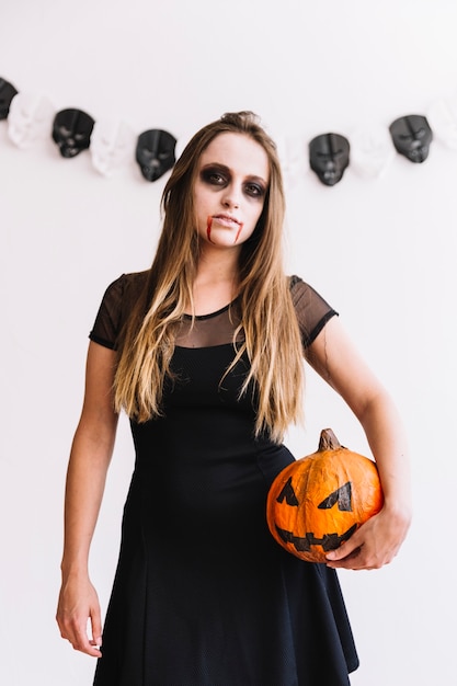 Free photo teenage girl with vampire grim and pumpkin