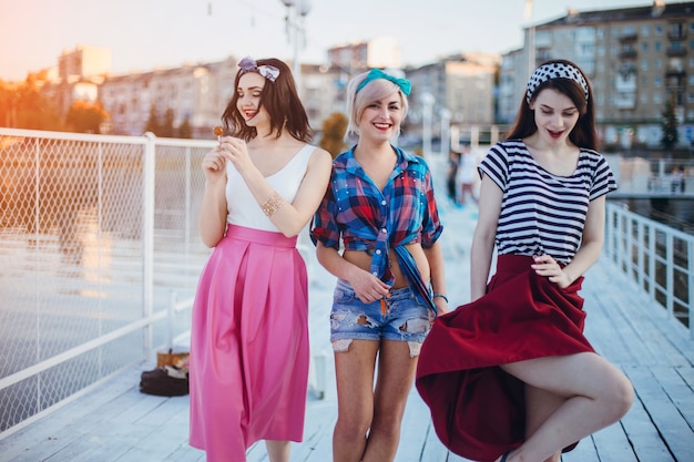 Teenage girls smiling while strolling by a harbor