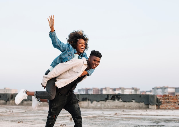 Free photo teenager carrying young girl outdoors