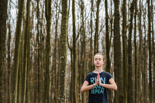 Free Photo teenager doing yoga and relaxing in forest