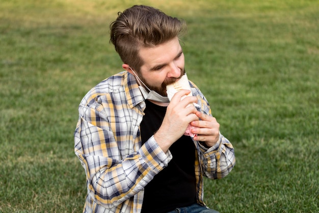 Teenager eating kebab out in the park