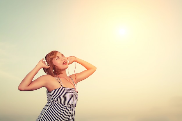 Free Photo teenager enjoying music with sky background