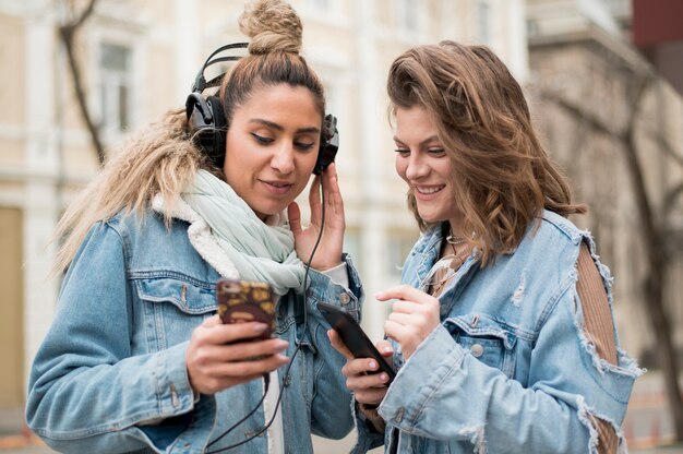 Teenager friends sharing songs outdoors