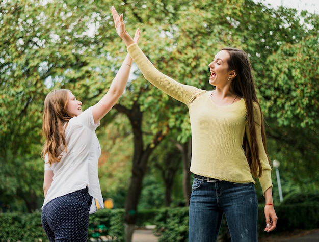 Teenager girls high five in air