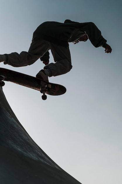 Teenager having fun with skateboard at the park outside